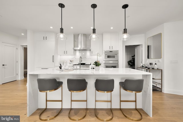 8551 Connecticut Ave Unit 210, Chevy Chase, MD 20815 - kitchen with pendant lighting, wall chimney range hood, an island with sink, tasteful backsplash, and stainless steel double oven