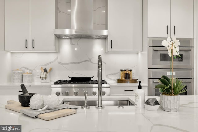 8551 Connecticut Ave Unit 210, Chevy Chase, MD 20815 - kitchen featuring wall chimney range hood, double oven, tasteful backsplash, light stone counters, and white cabinetry