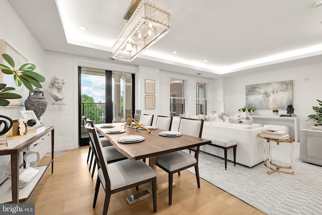 8551 Connecticut Ave Unit 210, Chevy Chase, MD 20815 - dining room featuring a tray ceiling, light hardwood / wood-style flooring, and a chandelier