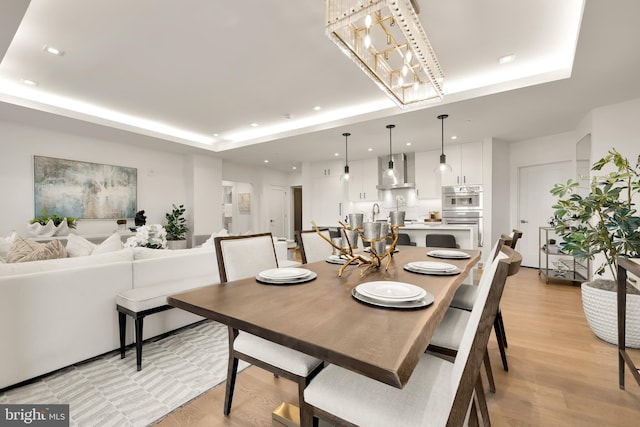 8551 Connecticut Ave Unit 210, Chevy Chase, MD 20815 - dining area with light hardwood / wood-style floors, a raised ceiling, and an inviting chandelier