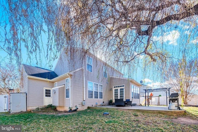 rear view of house featuring a yard and a patio