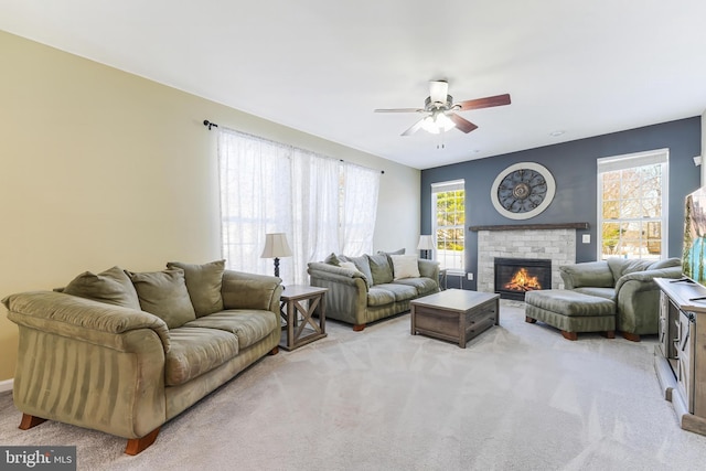 living room featuring ceiling fan, light colored carpet, and a brick fireplace