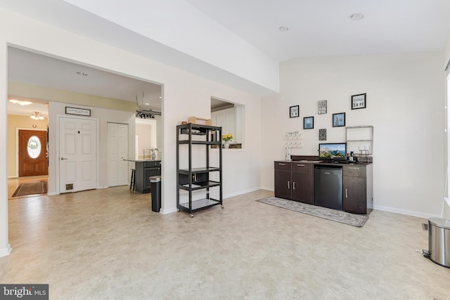 bar featuring lofted ceiling, fridge, and dark brown cabinetry