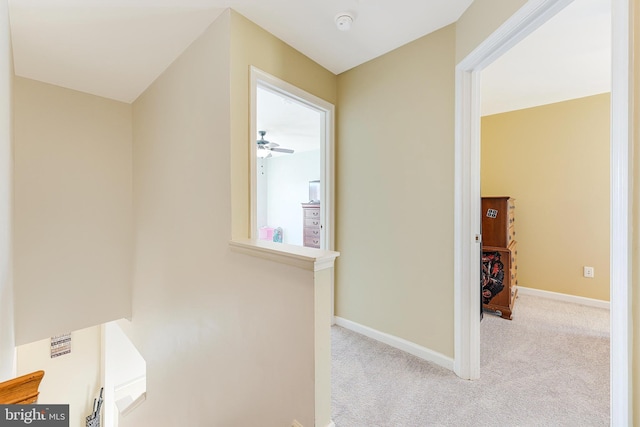 hallway featuring light colored carpet