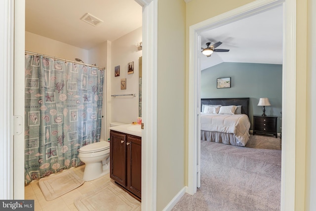 bathroom featuring vaulted ceiling, toilet, ceiling fan, and vanity