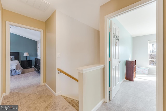 hallway featuring light colored carpet and vaulted ceiling