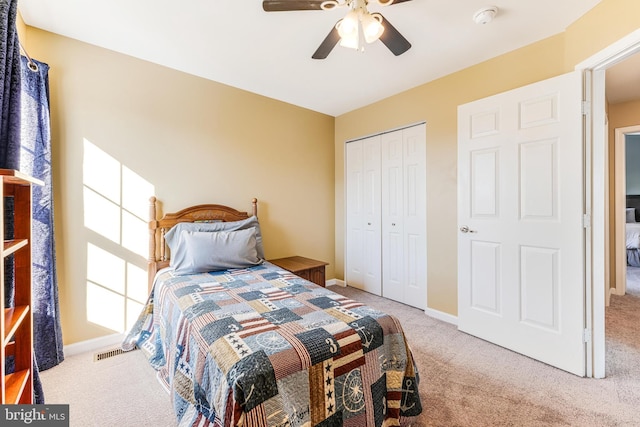 carpeted bedroom featuring ceiling fan and a closet