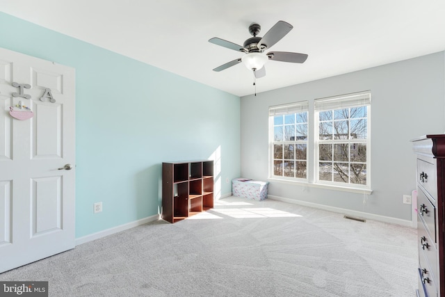 interior space with light carpet and ceiling fan