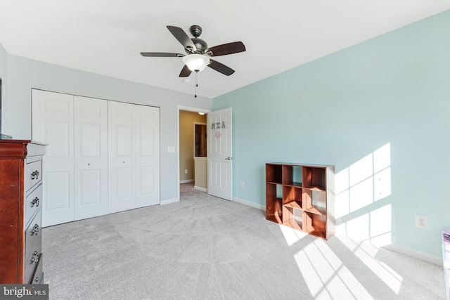 unfurnished bedroom with ceiling fan, a closet, and light carpet