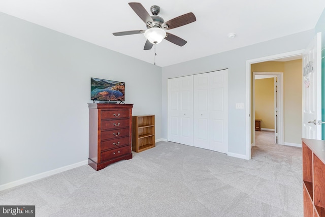 bedroom featuring ceiling fan, a closet, and light carpet