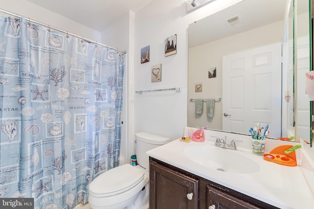 bathroom featuring curtained shower, vanity, and toilet