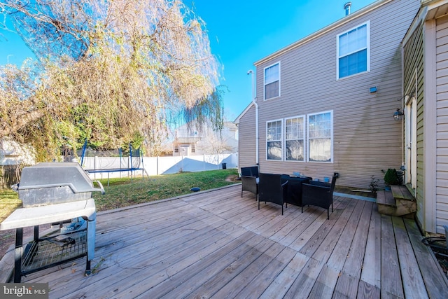 wooden terrace with a yard, area for grilling, and a trampoline