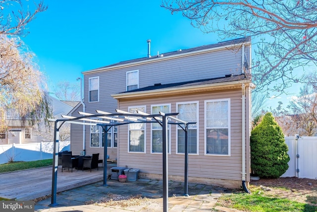 rear view of house featuring a pergola and a patio