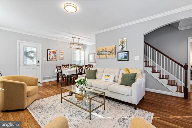 living room with crown molding, an inviting chandelier, and hardwood / wood-style flooring