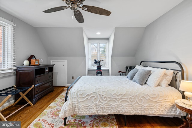 bedroom featuring multiple windows, hardwood / wood-style floors, vaulted ceiling, and ceiling fan