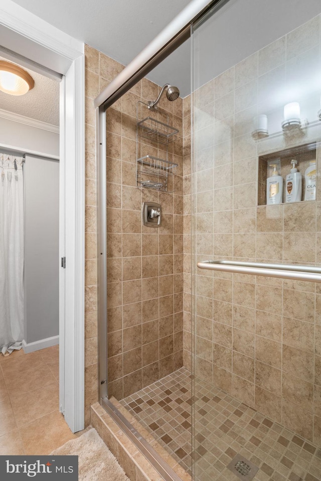 bathroom featuring tile patterned flooring, ornamental molding, and walk in shower