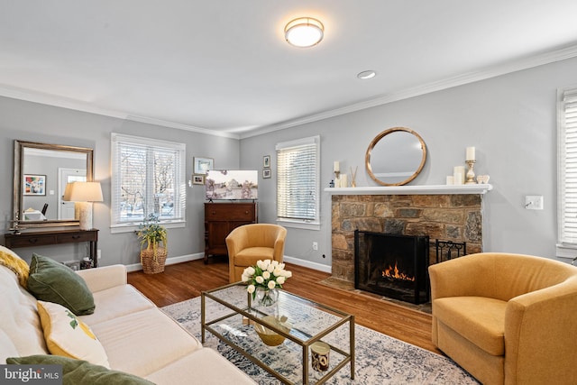 living room with plenty of natural light, a stone fireplace, and wood-type flooring