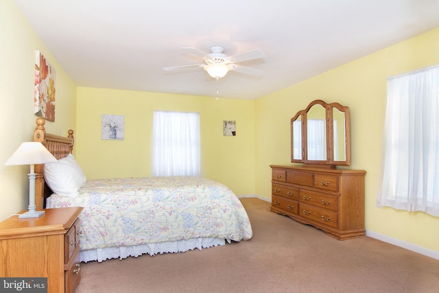 bedroom with a ceiling fan, baseboards, and carpet floors