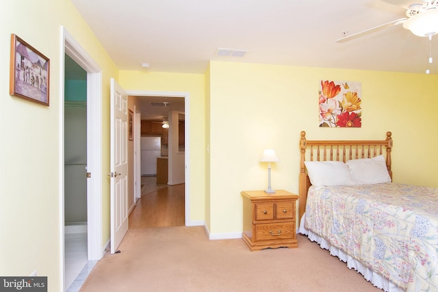 carpeted bedroom with white fridge and ceiling fan