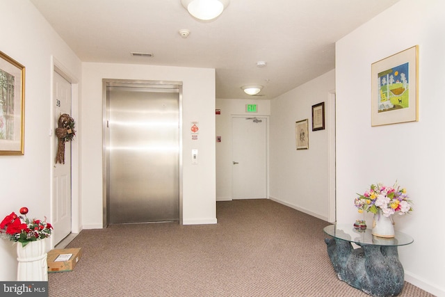 hallway featuring elevator and carpet