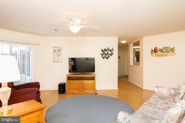 living room featuring light wood-style flooring, visible vents, and ceiling fan