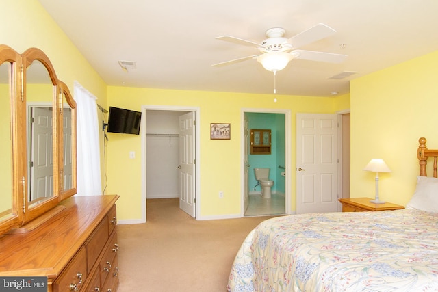 carpeted bedroom with a walk in closet, connected bathroom, ceiling fan, and a closet