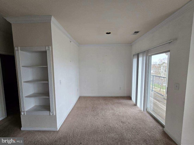 empty room with carpet flooring, crown molding, and built in features