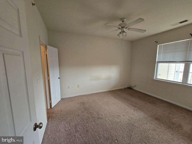 carpeted spare room featuring ceiling fan