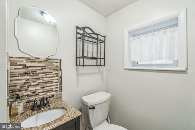 bathroom featuring decorative backsplash, vanity, and toilet