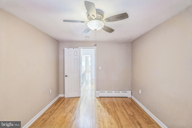 unfurnished room with ceiling fan, a baseboard radiator, and light wood-type flooring