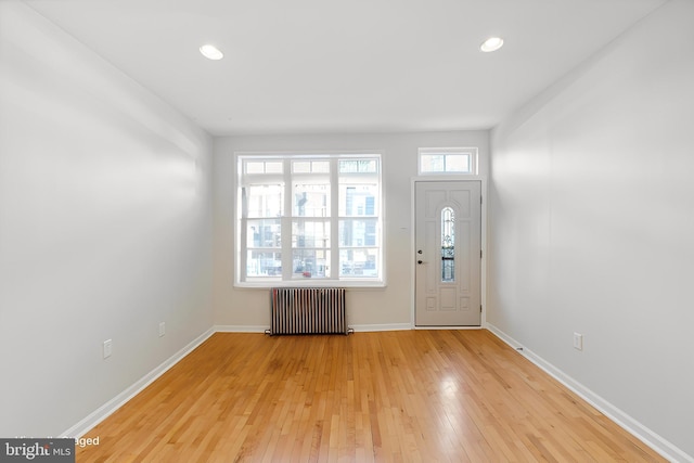 foyer featuring radiator and light hardwood / wood-style flooring