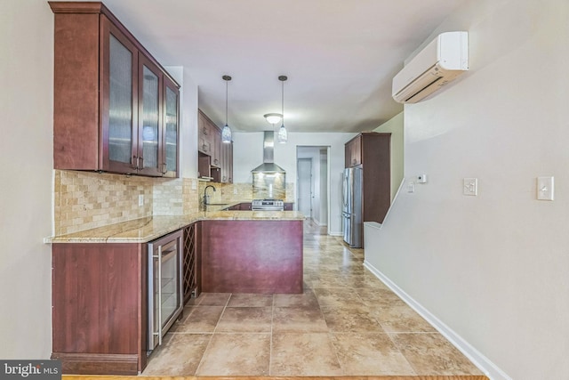 kitchen with backsplash, wall chimney exhaust hood, stainless steel appliances, a wall unit AC, and sink