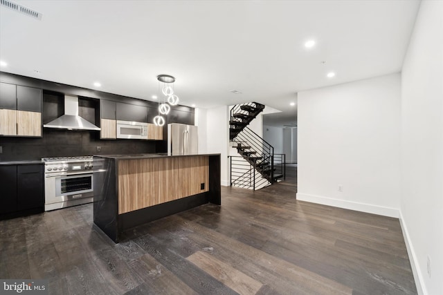 kitchen with stainless steel appliances, wall chimney range hood, dark hardwood / wood-style floors, decorative backsplash, and a kitchen island