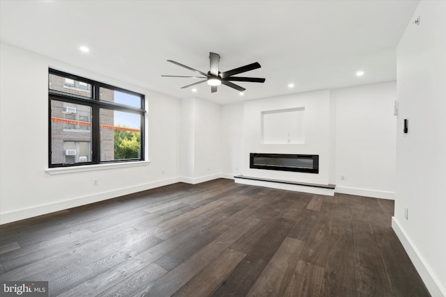 unfurnished living room with ceiling fan, dark hardwood / wood-style flooring, and a baseboard heating unit