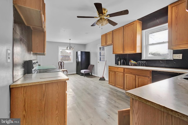 kitchen with ceiling fan with notable chandelier, tasteful backsplash, black appliances, light hardwood / wood-style floors, and decorative light fixtures