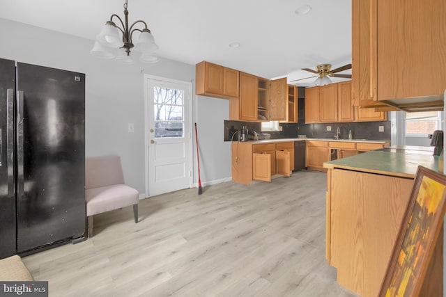 kitchen with ceiling fan with notable chandelier, backsplash, black appliances, decorative light fixtures, and light wood-type flooring