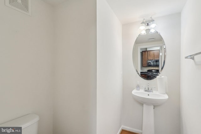 bathroom with toilet and a chandelier