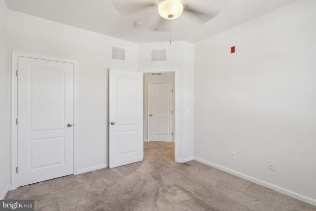 unfurnished bedroom with ceiling fan and light colored carpet