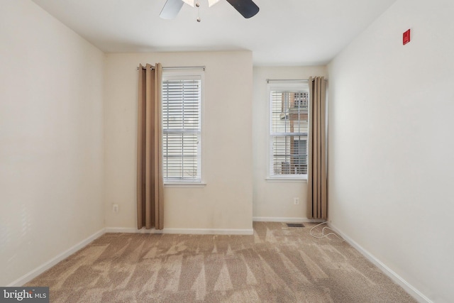 spare room featuring ceiling fan and light colored carpet