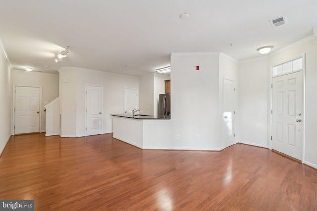 interior space with hardwood / wood-style floors, ornamental molding, and sink