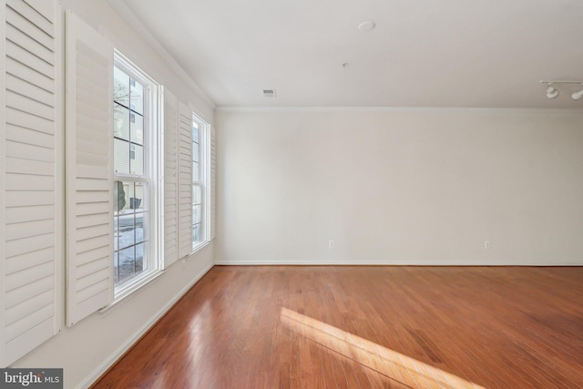 unfurnished room featuring crown molding and hardwood / wood-style floors