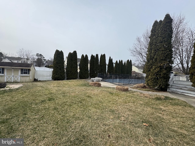 view of yard with a pool and a storage shed