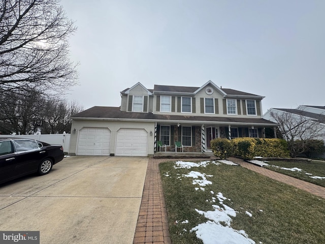 view of front of property featuring a front lawn, a garage, and a porch