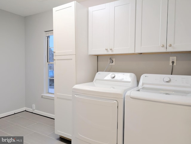 laundry room featuring cabinets, light tile patterned flooring, and washing machine and dryer