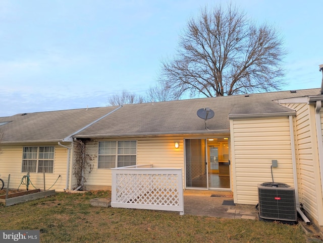 back of house with central AC unit, a patio area, and a lawn