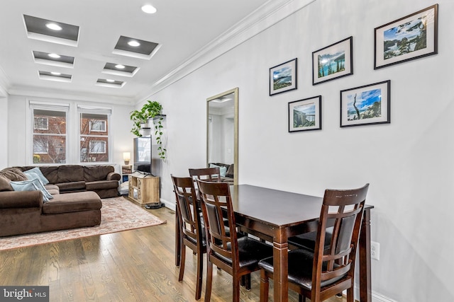 dining space with coffered ceiling, hardwood / wood-style flooring, and ornamental molding