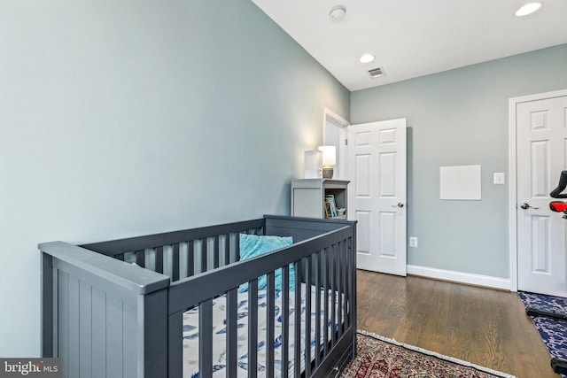 bedroom with dark hardwood / wood-style flooring