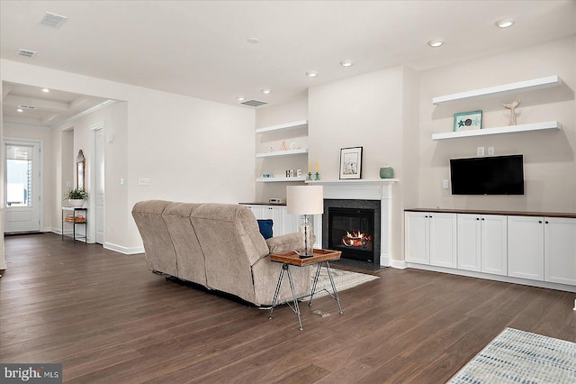 living room featuring dark hardwood / wood-style flooring and built in shelves