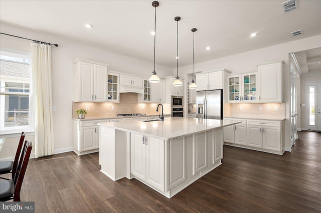 kitchen featuring white cabinetry, a center island with sink, and appliances with stainless steel finishes