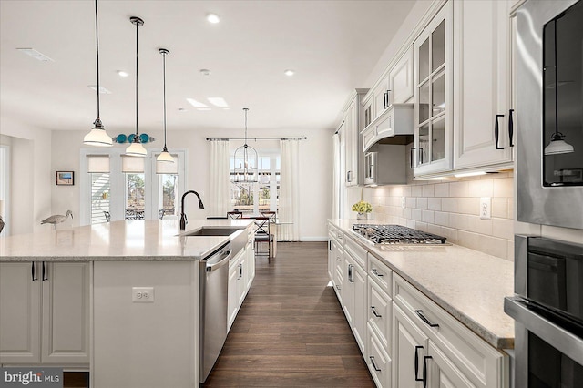 kitchen with white cabinetry, decorative light fixtures, and light stone counters